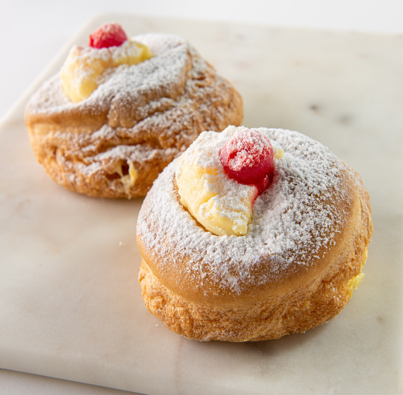 Two zeppole on a white counter.